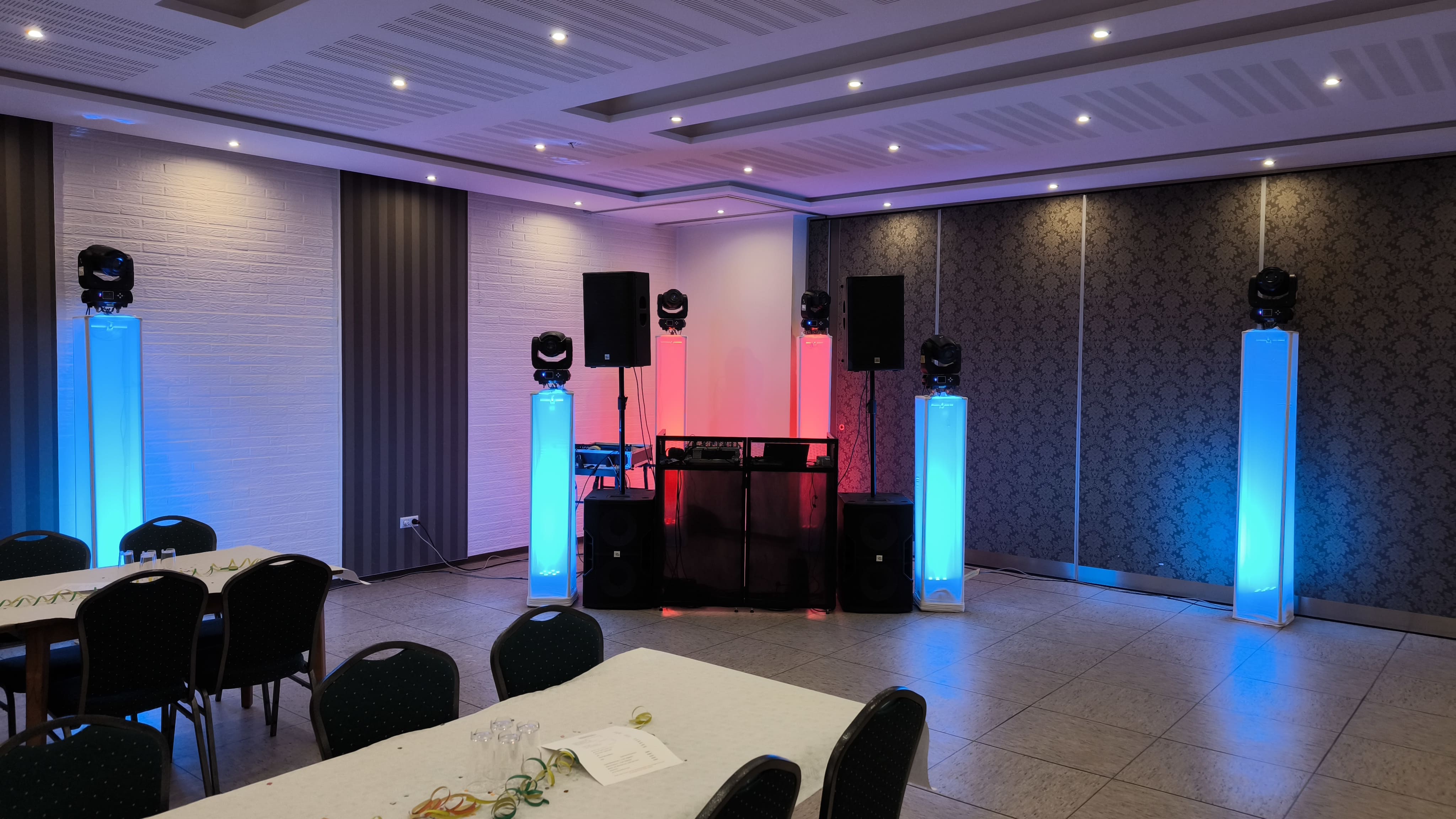 Nahaufnahme einer Hand am DJ-Mixer mit rotem und violettem Licht