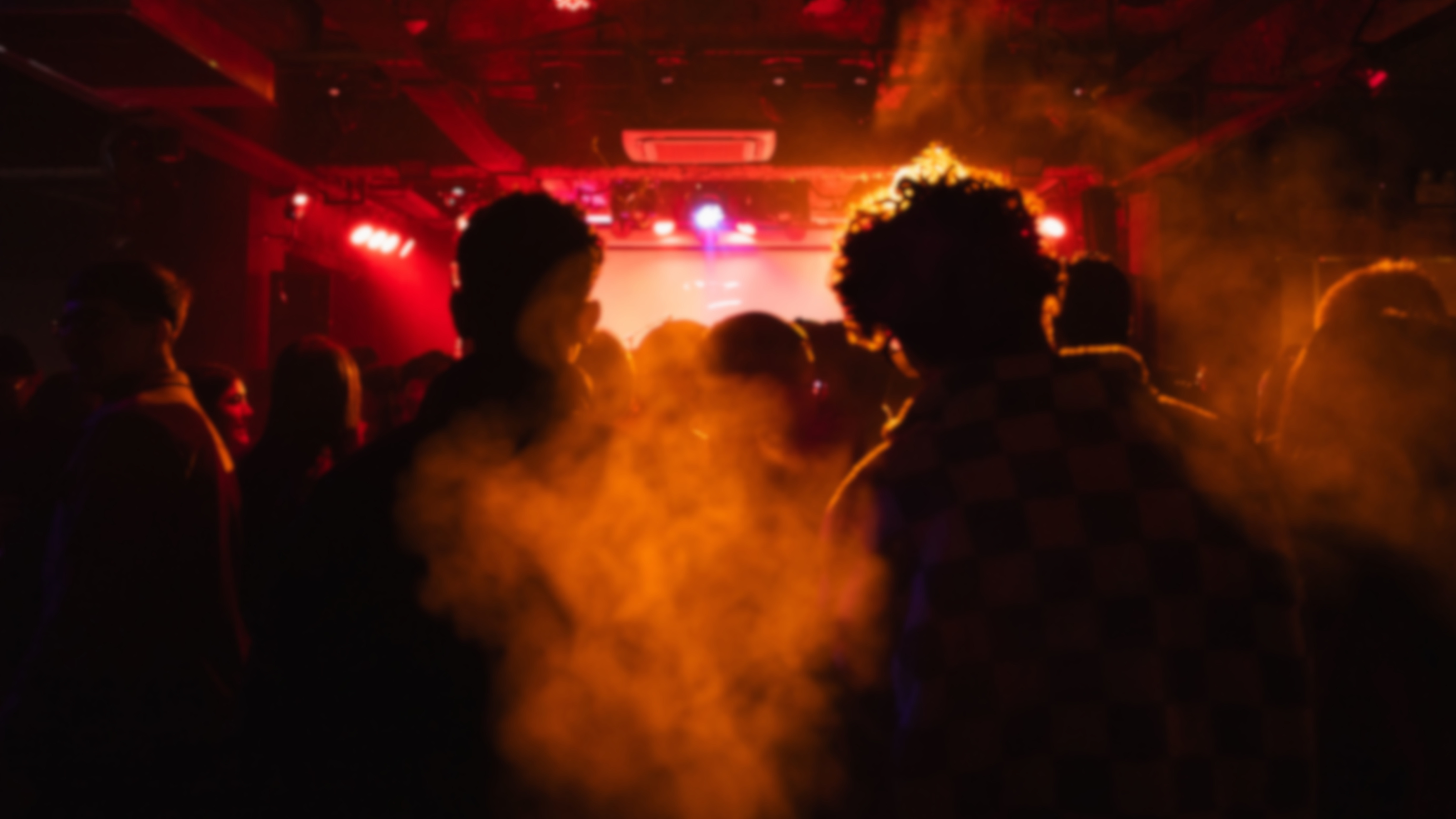Bunte Lichtstrahlen und Konfetti über einem Konzertpublikum